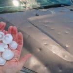 prod_pdr hand holding hail in front of dented car