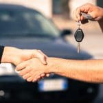 transferring ownership car transfer of keys while handshake, car in background