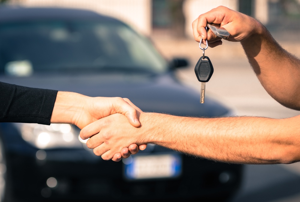 transfer of keys while handshake, car in background