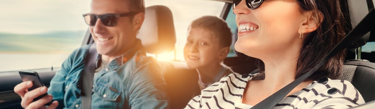 Happy family riding in a car .